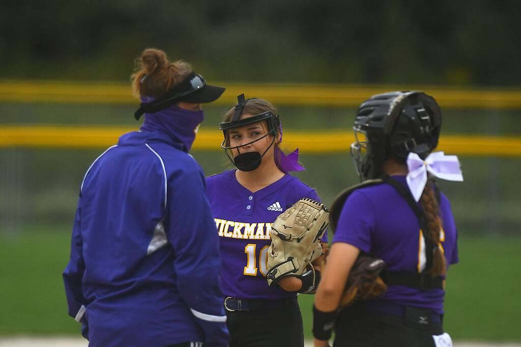 From left, Hickman head coach Courtney Haskell speaks to players Emma Henley and Miette Hall during their game against